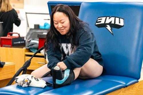 A student practices ice wrapping their leg in an athletic training lab