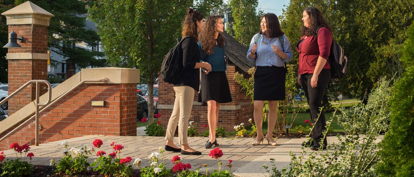 three students gather outside on the portland campus in spring