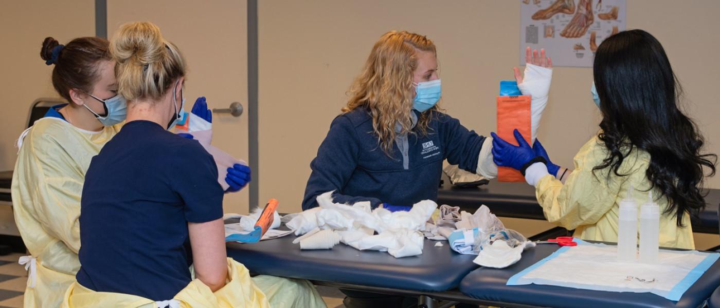 A group of P A students practice placing casts on each other's arms