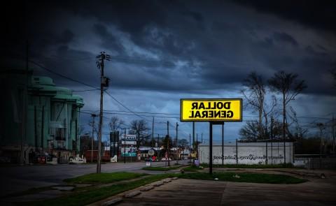 A Dollar General sign is illuminated against a dark sky